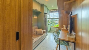 Una cocina moderna con refrigerador empotrado, un comedor con mesa y sillas, y un sofá en la sala de estar.