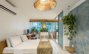 Una habitación de hotel moderna con una cama, un escritorio y un ventanal grande.