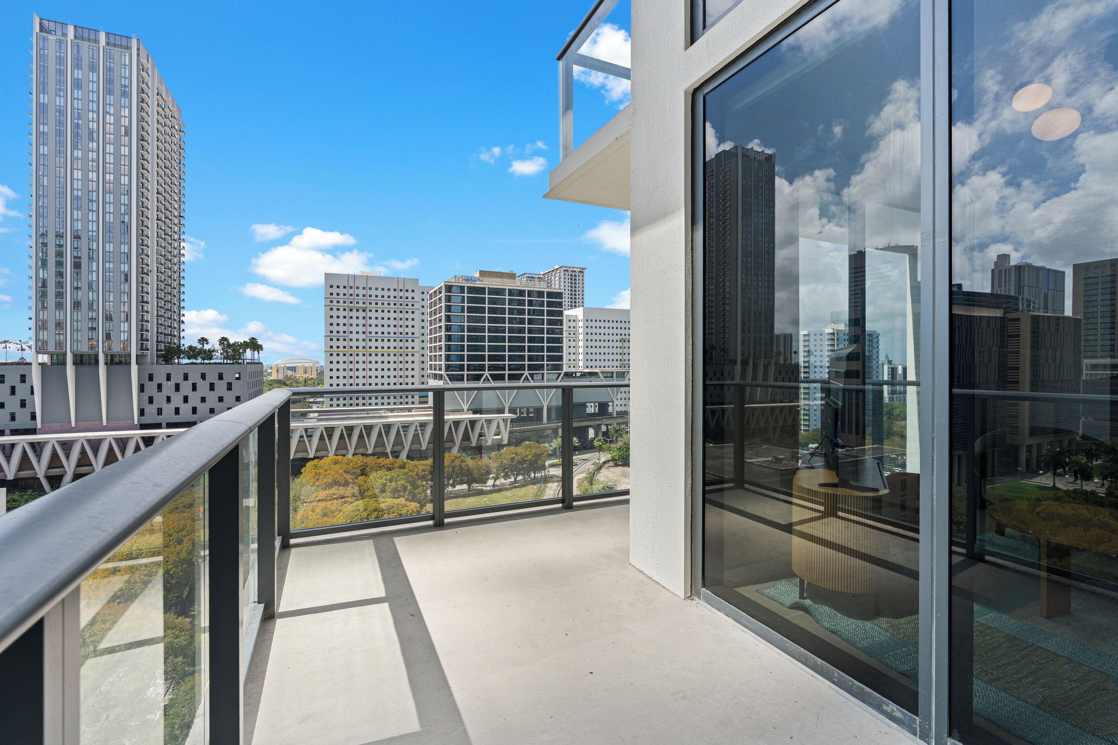 A modern building with a balcony overlooking a cityscape.