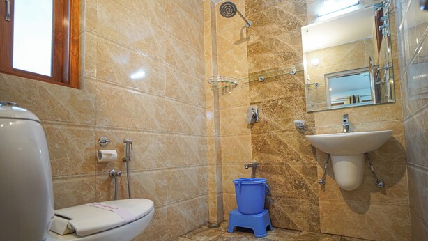 Een badkamer met toilet, douche en wastafel.