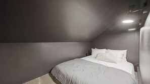 Una camera da letto con un letto singolo, un comodino e un lampadario.