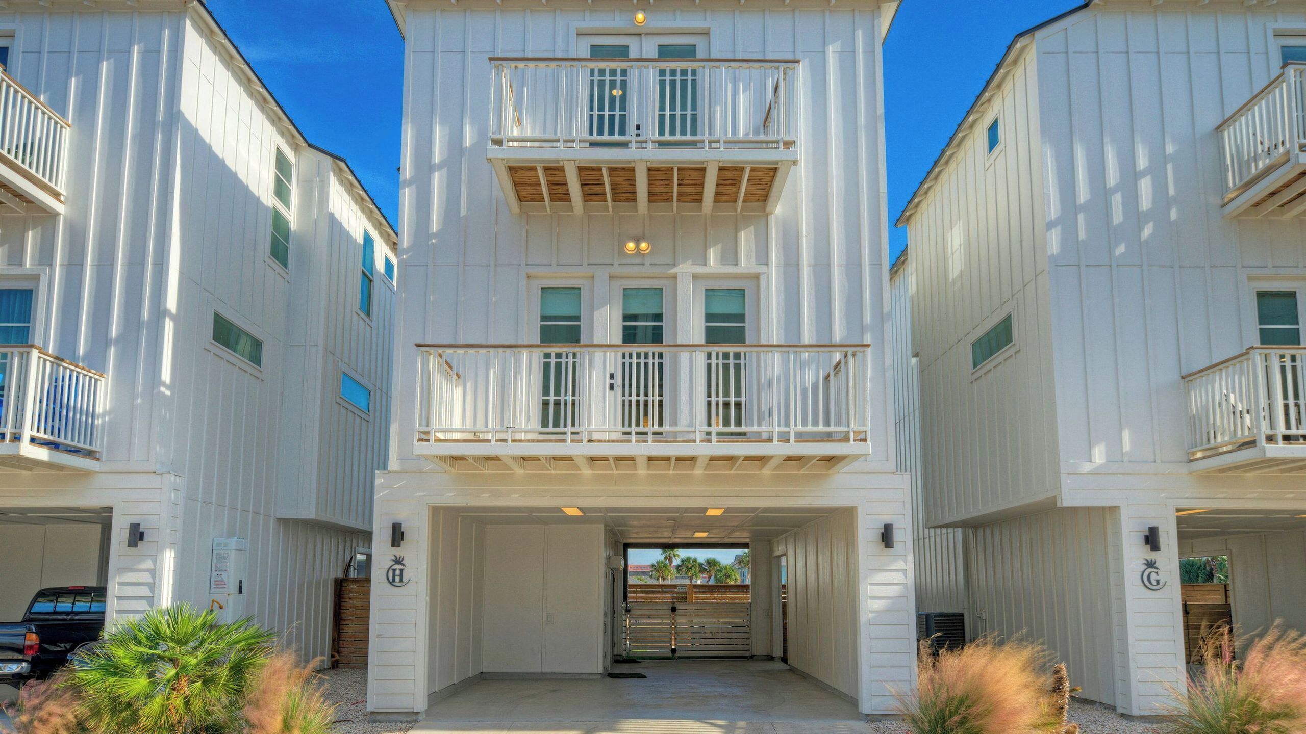 A multi-story building with a central entrance, balconies, and a garage.