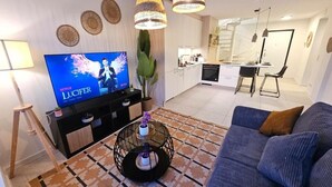 A modern living room with a television, sofa, and decorative items. - New 2BR Flat in Limpertsberg City center (Luxembourg City)