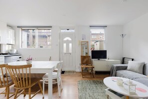 Un appartement moderne comprenant un coin repas, un salon et une kitchenette.