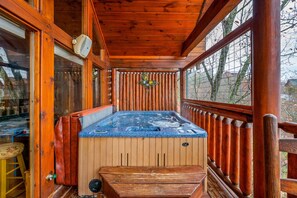 A wooden cabin with a hot tub, wooden deck, and large windows. - Smokies Mountain Charm: Views, Hot Tub, Game Room! (Sevierville)