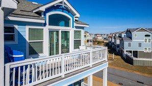 A row of coastal houses with balconies, featuring a prominent blue and white color scheme. - 8Min Walk2Beach,Hot tub, GameRM, Family (Corolla)