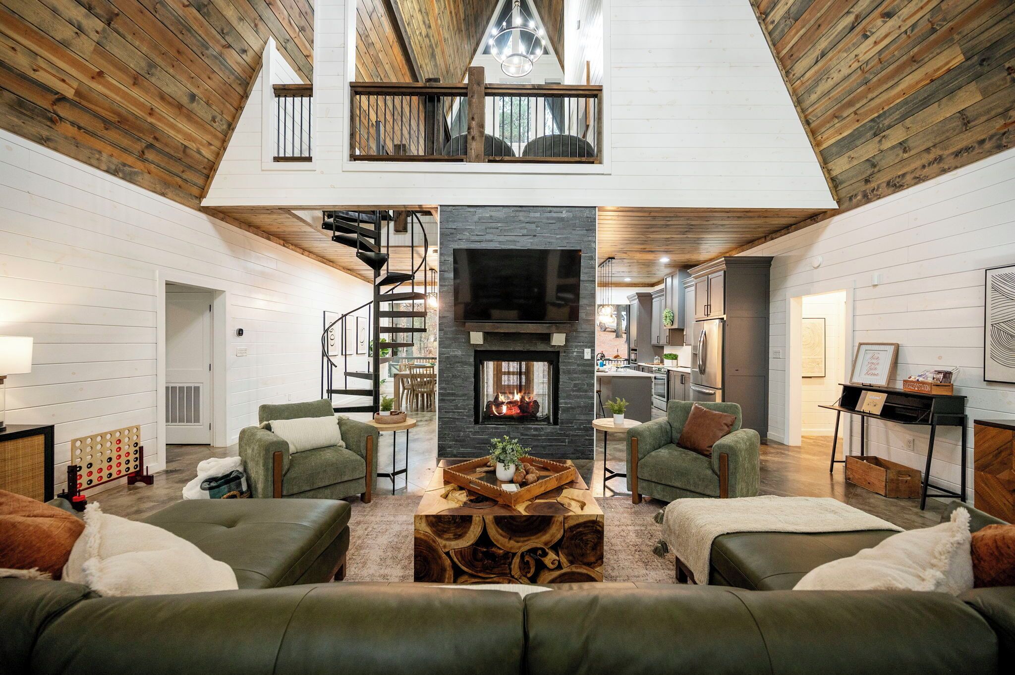 Un vaste espace de vie doté d’un haut plafond, d’une cheminée et d’une mezzanine avec balcon.