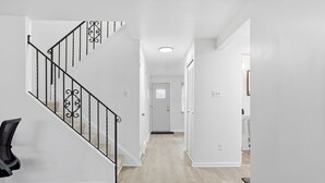 Een modern interieur met een trap, een gang en een deur naar een andere kamer.