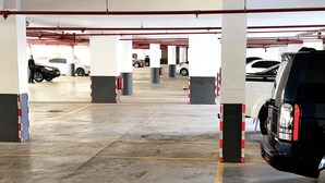 A multi-level parking garage with concrete floors and yellow parking lines. - Modern 1-bedroom Near Airport & Nairobi National Park (Nairobi)