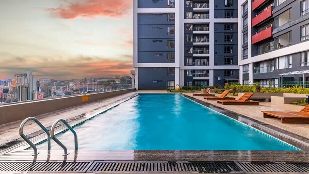 A rooftop swimming pool with a city view, surrounded by modern buildings. - Modern 1-bedroom Near Airport & Nairobi National Park (Nairobi)