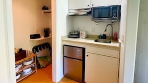 Cuina petita amb armaris blancs, microones, torradora i rentavaixelles.