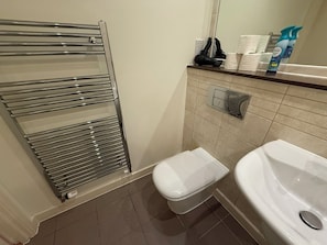 A bathroom with a glass shower enclosure, a toilet, and a sink. - Bright 1BDR Apartment with Park Views in Leyton (Greater London)