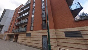A multi-story building with a brick facade, large windows, and a visible balcony on the upper floors. - Bright 1BDR Apartment with Park Views in Leyton (Greater London)