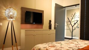 A bedroom with a bed, a television, a cabinet, and a decorative tree on the wall. - "The Church Fields - Dream Stay" Rust nabij natuur & met gratis parkeerplaats (Brunssum)