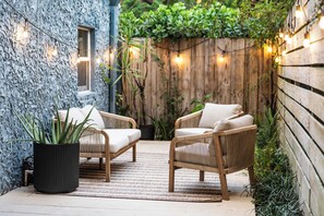 A cozy outdoor seating area with wicker chairs and a potted plant.