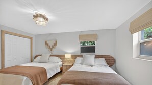 A bedroom with two beds, a ceiling light fixture, a window with a view, and a door. - Little Havana Cabana – Retro Surf-Lodge Hideaway (Miami)