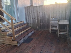 A wooden deck with a staircase leading to a covered area, surrounded by a wooden fence. - New studio in Corse-du-Sud (Figari)