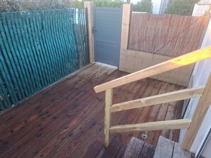A wooden deck with a metal gate and a blue fence. - New studio in Corse-du-Sud (Figari)