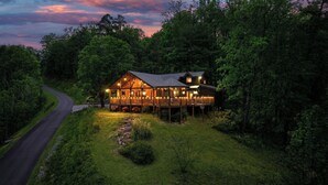 A large wooden cabin with multiple decks and a porch, surrounded by dense forest. - Mountain Views, Family Getaway, Pet Friendly, Game Room, Sleeps 9 (Sevierville)