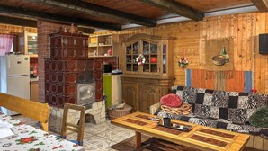 Eine rustikale Küche mit einem Holzkabinett, einem eingebauten Ofen und einem Essbereich mit einem gemusterten Sofa und einem Tisch.