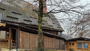 Eine rustikale Holzhütte mit Metalldach und einem kleinen Anbau.