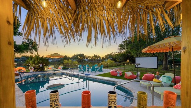 A pool area with lounge chairs and tiki-style vases. - Sleeps 12 • Game Room • Theatre • Tiki Bar • Pool (Bradenton)