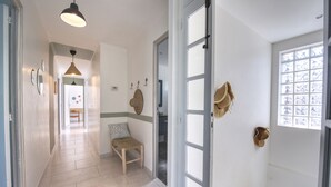 A hallway with a bench, a hanging light fixture, and a door with a window. - L'Oustal Occitan: Idyllic Family Escape with Private Pool (Saint-Privat-des-Vieux)
