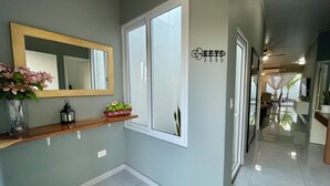 Um corredor com um espelho, um aviso de boas-vindas e uma porta com um chaveiro.