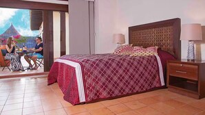Quarto com cama, mesa de cabeceira e vista para uma sala de jantar com duas pessoas.