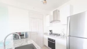 Una cucina moderna con lavello in acciaio inossidabile, forno integrato e frigorifero.