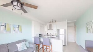 Un soggiorno moderno con un divano grigio, un tavolino da caffè e una ventola a soffitto.