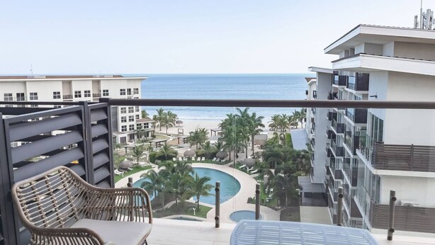 Un balcone con vista sull'oceano, una piscina e una zona resort.