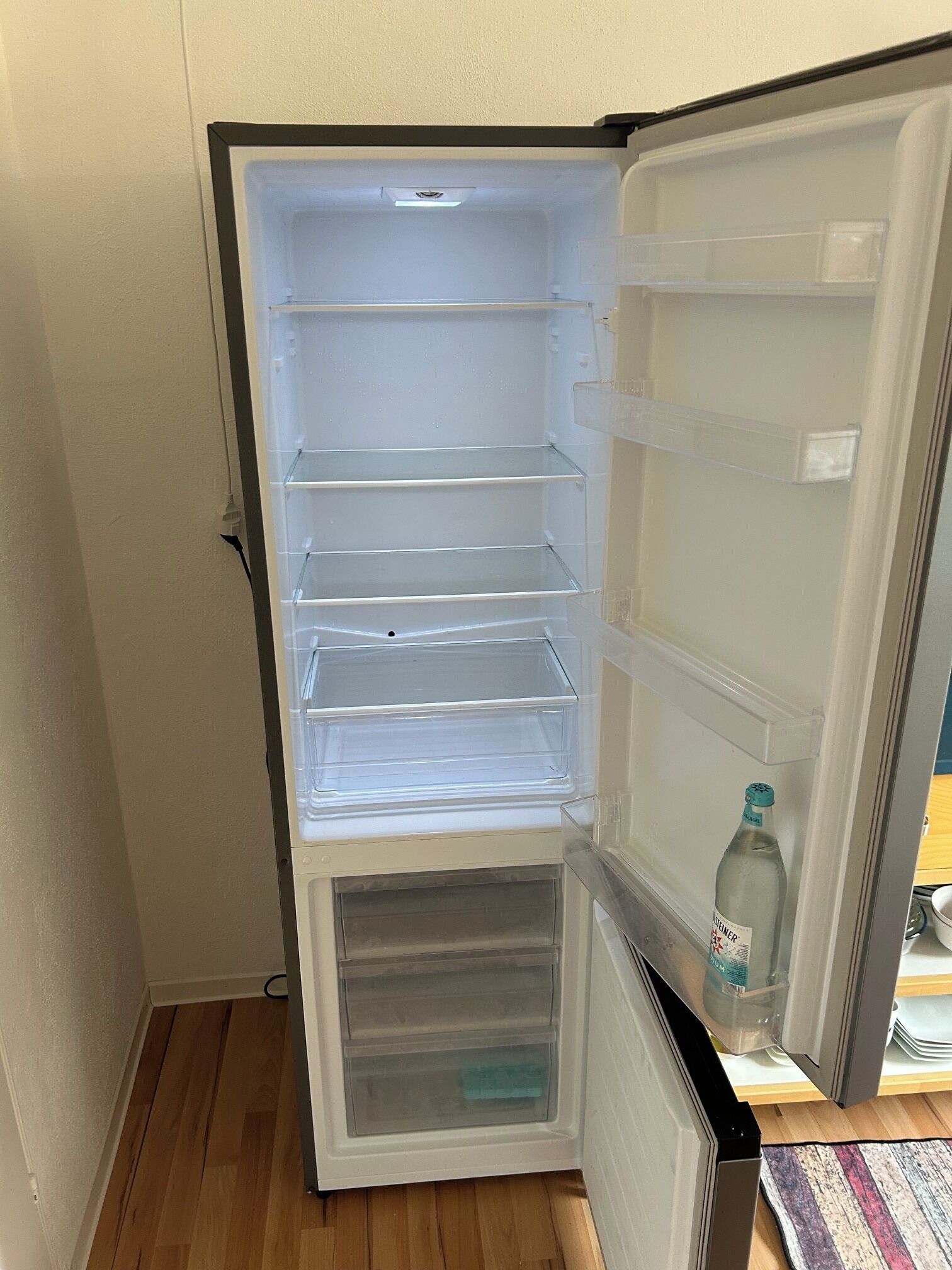 An open refrigerator with multiple shelves and a freezer compartment.