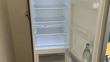 An open refrigerator with multiple shelves and a freezer compartment.