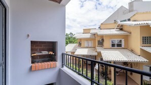 A balcony with a brick shelf, a metal railing, and a view of neighboring buildings with tiled roofs. - 1-br APT w/ Bbq, 800m From the Sea Dfc0101 (Florianópolis)