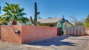 A house with a paved driveway, a wooden fence, and a cactus in the yard. - Fire Pits & Grill at Central Tucson Home Base! (Tucson)