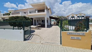 A modern two-story house with a covered patio and a gated entrance. - Belsol House (Altura)