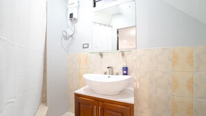 Une salle de bain avec un lavabo blanc, un meuble en bois et des carreaux décorés.
