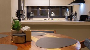 Une cuisine moderne avec une table à manger, une machine à café et une plante.