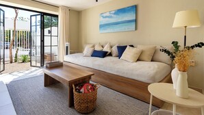 Un salon moderne avec un canapé, une table basse, une lampe et un tableau représentant une scène de plage.