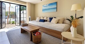 Ein modernes Wohnzimmer mit einer Couch, einem Couchtisch, einer Lampe und einem Bild mit einer Strandansicht.