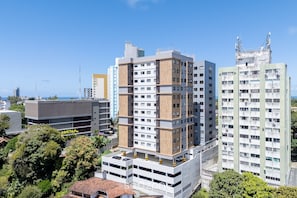 A multi-story building with a modern design, featuring a mix of white and wooden paneling, and a flat roof. - Fully Equipped Apts With Leisure Minutes From the Beach Hfos (Salvador)