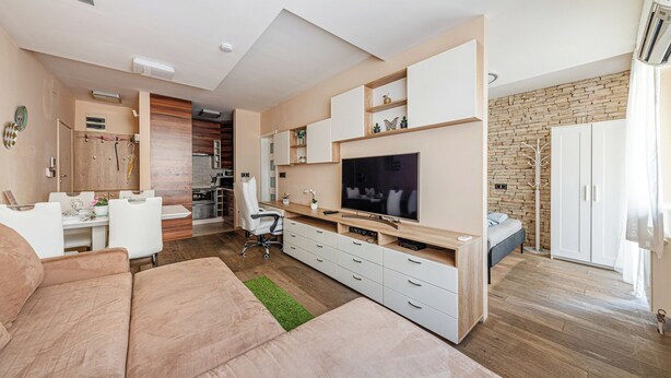 A modern living room with a sofa, TV, and a dining area with a table and chairs. - La Dolce Vita –Massage Shower Stay W/ Ac + Balcony (Budapest)