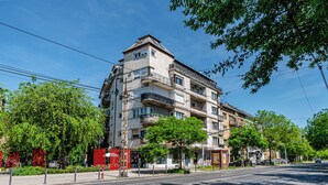 Un immeuble à plusieurs étages doté de balcons, avec une entrée bien visible et une rue devant.