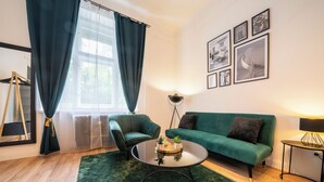 Ein modernes Wohnzimmer mit einem grünen Sofa, einem runden Couchtisch und einem grünen Teppich.