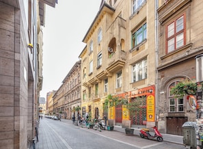 Eine Straße mit historischen Gebäuden, einem Restaurant namens 'El Rapito' und einem Roller, der am Bürgersteig geparkt ist.