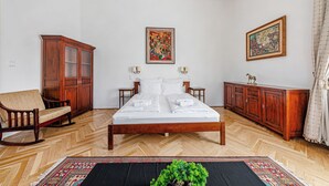 Een hotelkamer met een houten bed, een bank, een kast en een vloerkleed.