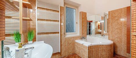 Un baño moderno con una bañera grande, un lavamanos independiente y un ventanal.