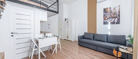 Un espace de vie moderne comprenant un coin repas, un canapé et un escalier.