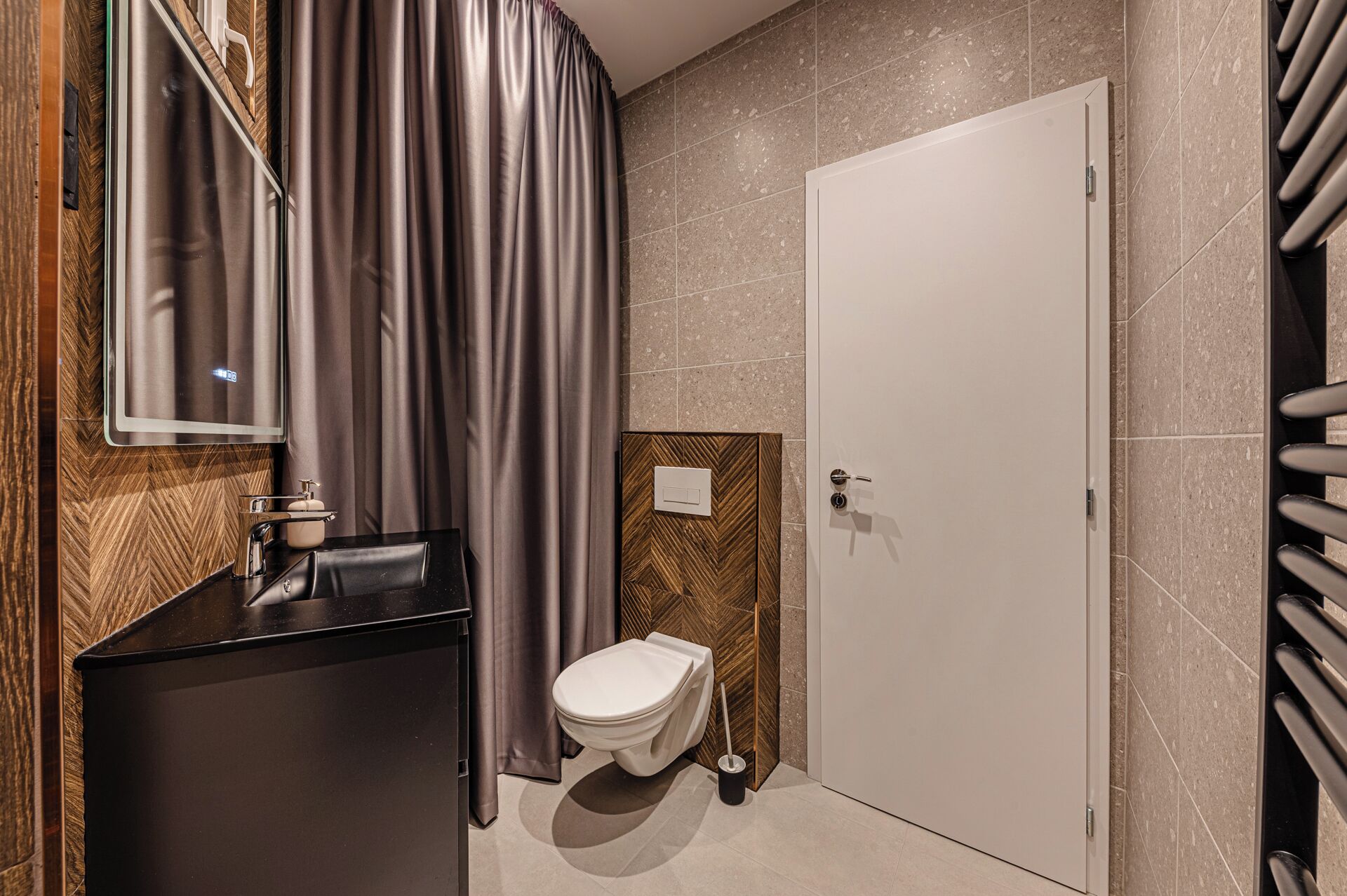 A modern bathroom with a toilet, sink, and mirror.